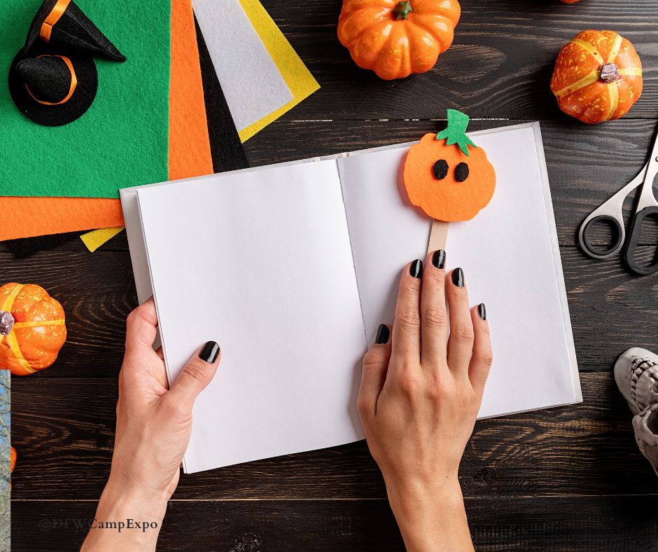 Pumpkins, along with fall-colored crafting supplies, including felt and paper, surround a pair of hands.