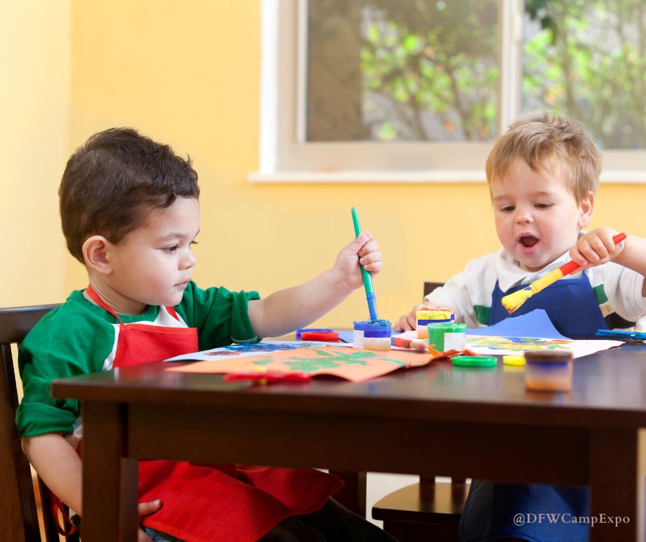 Two small boys do simple fall crafts for toddlers at a table.