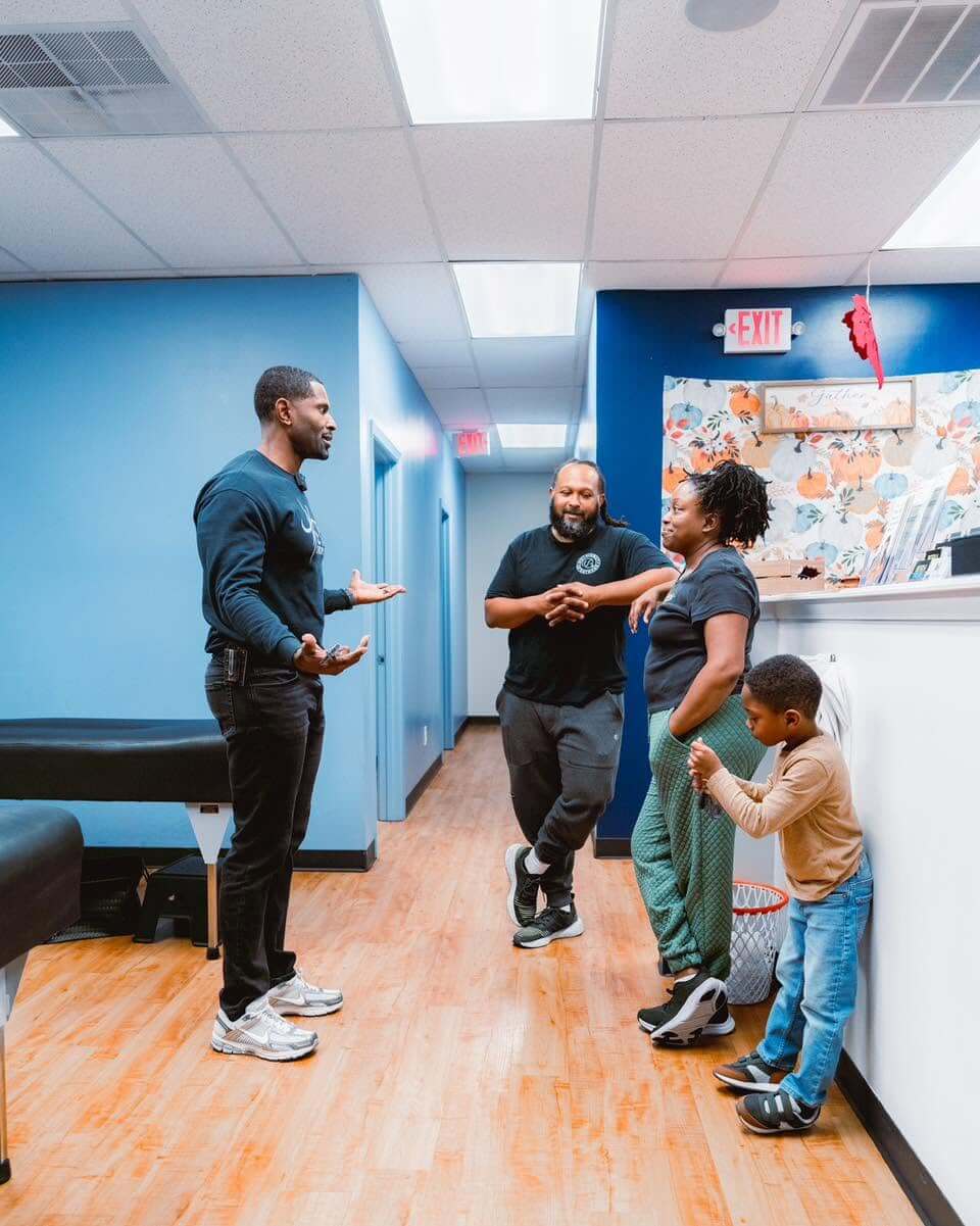 A chiropractor speaking with a family at CTC Chiropractic in Frisco