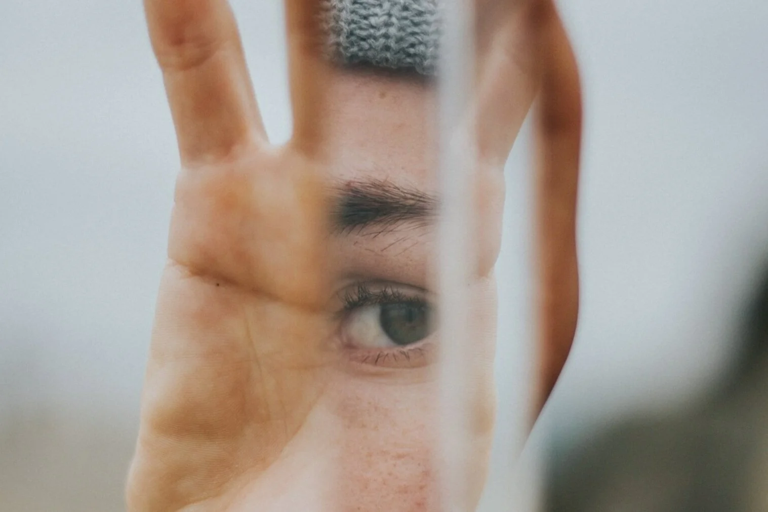 Close-up of an eye seen through an open hand